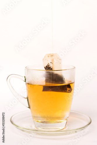 Tea bag dipped in the cup with hot water isolated on white background