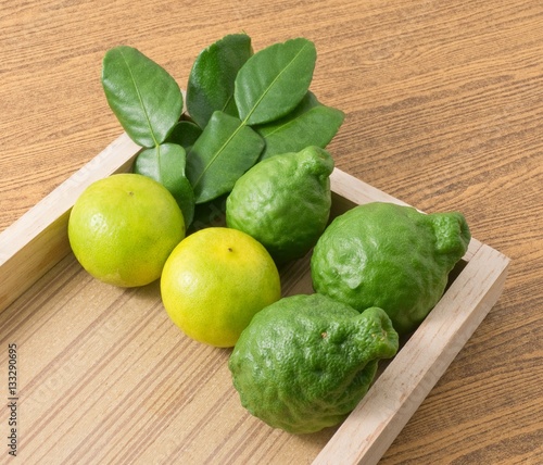 Green Kaffir Lime with Lemon Lime on Wooden Tray