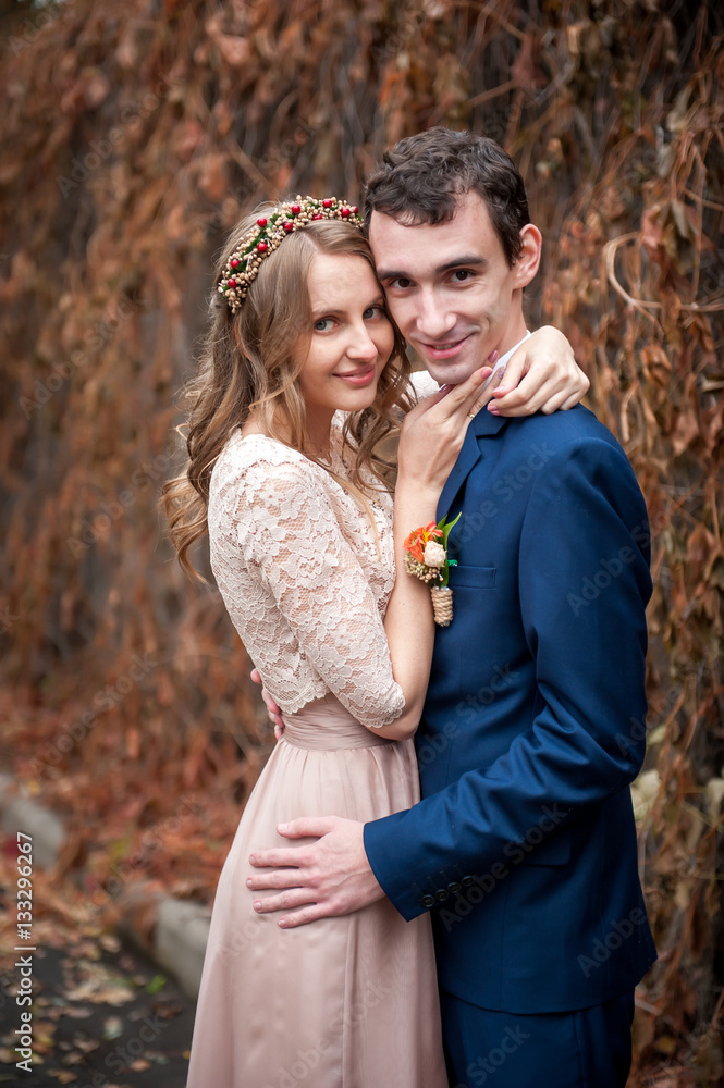 Portrait of happy newlyweds in autumn nature. Happy bride and gr
