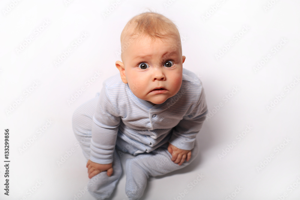 baby sits in a blue dress on the bed baby sits in a blue dress on the bed