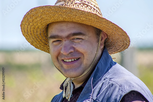 A farmer in a hat smiling