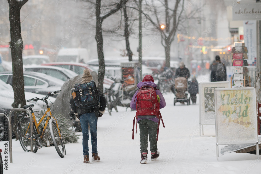 Pedestrians walking in covered with snow street