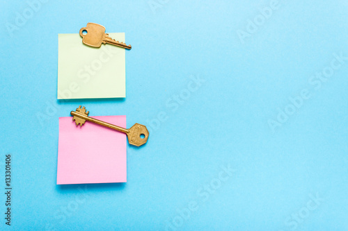 Adhesive note post and keys on a blue background