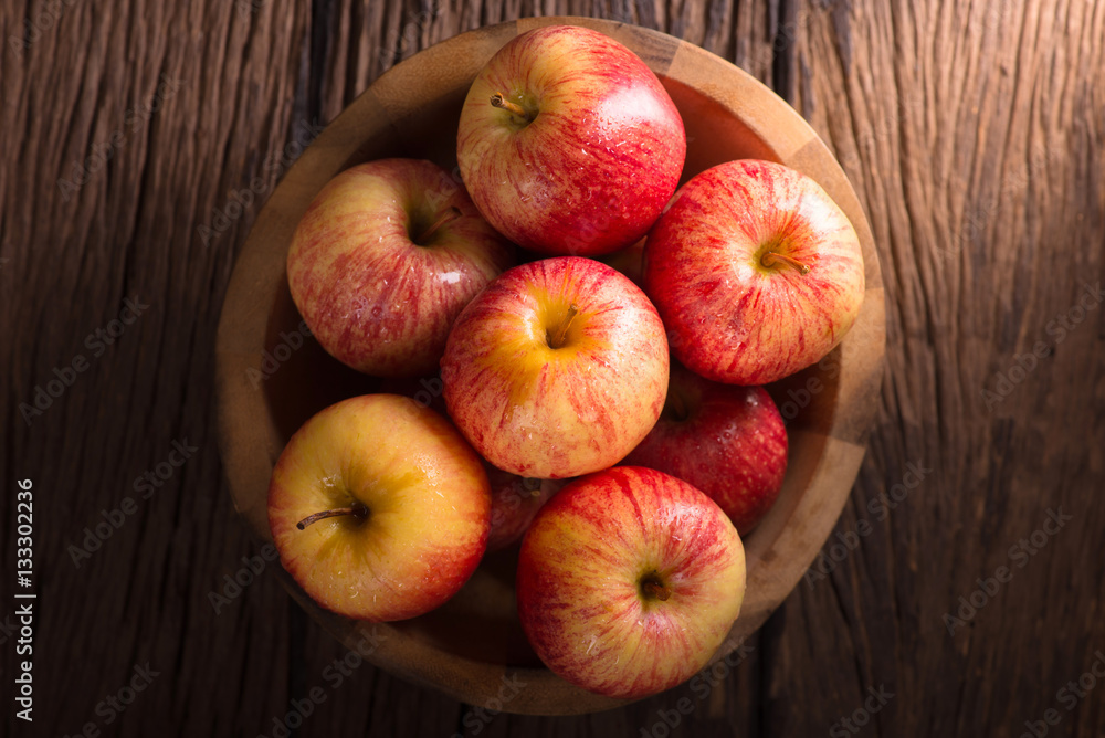 Red apples in a wooden bowl on dark background. Red apples in a wooden bowl on dark background.