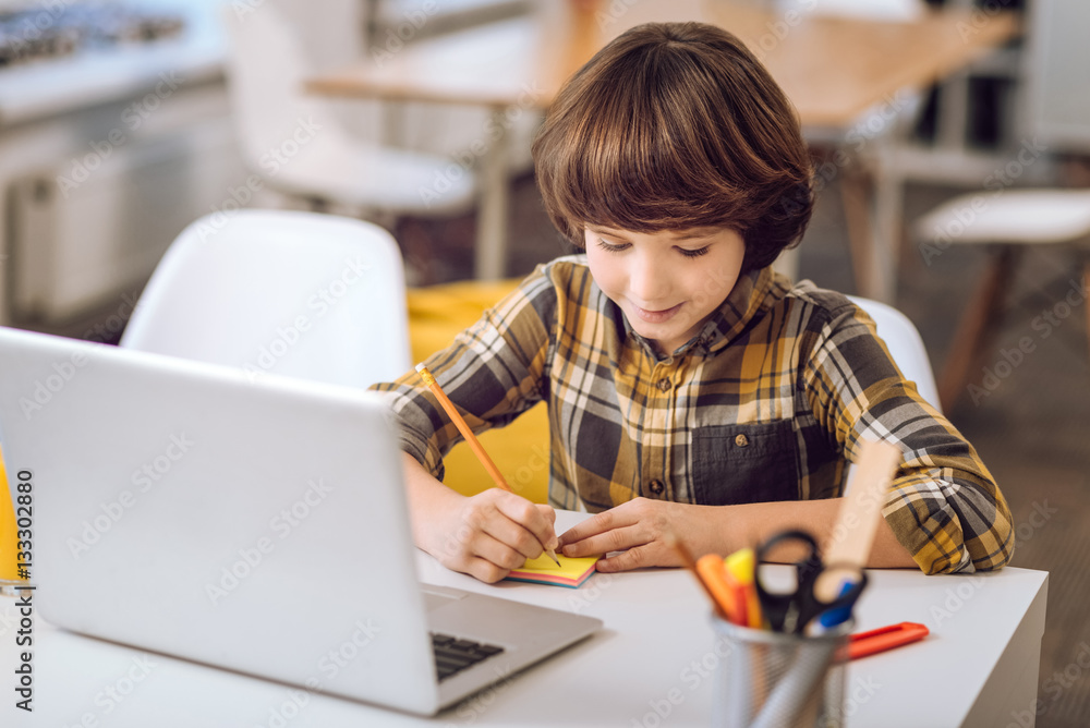 Little boy writing notes with pensil. Little boy writing notes with pensil.