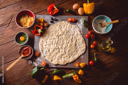 Preparing pizza with dough and tomato sauce