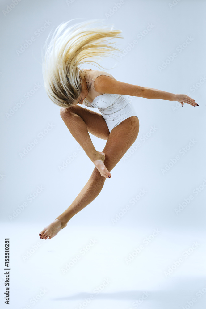 Fototapeta premium Woman dancer jump in studio on white background