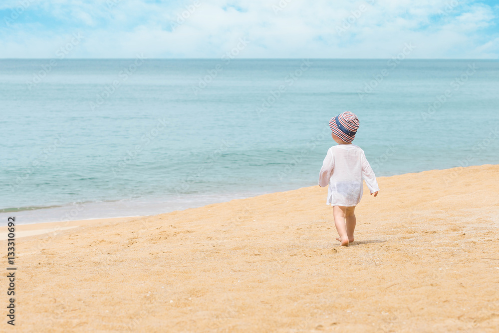 Adorable toddler girl playing on white sand beach. Adorable little girl walking at the beach. Adorable toddler girl playing on white sand beach. Adorable little girl walking at the beach.