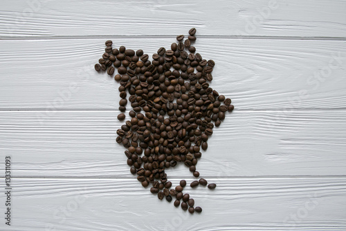 Map of the Northern America made of roasted coffee beans laying on white wooden textured background and space for text