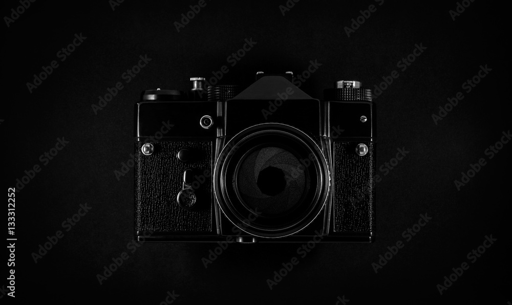 Fototapeta premium Old black SLR film camera with lens and aperture