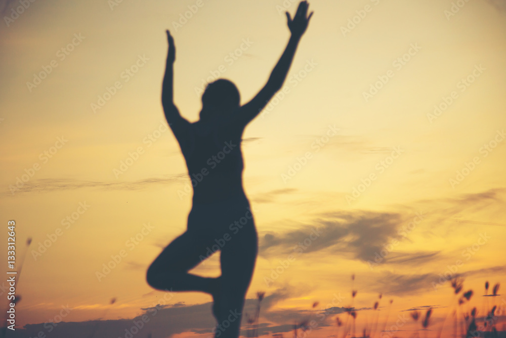 Silhouette of woman praying over beautiful sky background