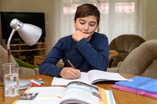 Tableau sur toile Young boy doing homework for school