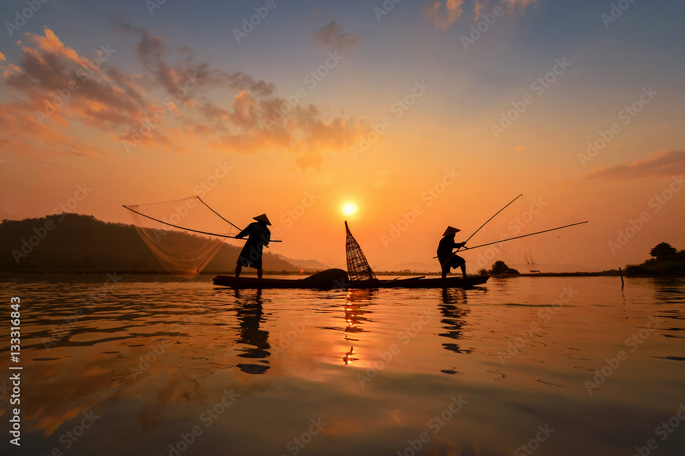 Silluate fisherman and boat in river on during sunrise,Thailand