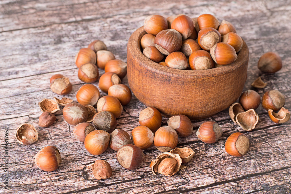Nuts filbert. Nuts filbert, whole and peeled, in a brown wooden bowl on old table. Nuts filbert. Nuts filbert, whole and peeled, in a brown wooden bowl on old table.