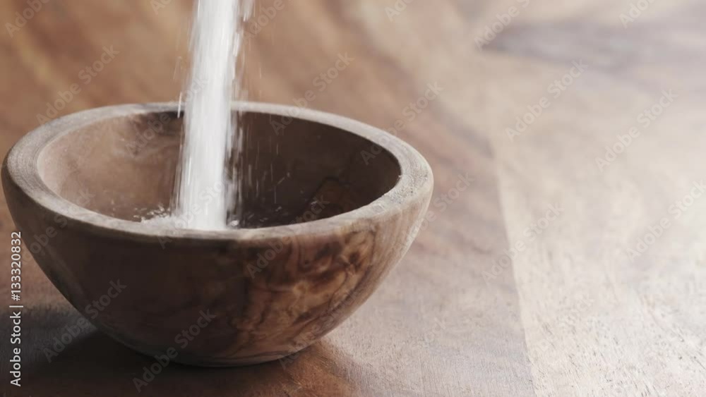white sugar falling in wood bowl on wooden table in slow motion, 180fps prores footage white sugar falling in wood bowl on wooden table in slow motion, 180fps prores footage