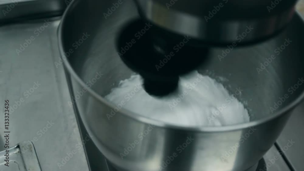 Close up: Whisks whipped egg whites and sugar in the bowl of glass Close up: Whisks whipped egg whites and sugar in the bowl of glass
