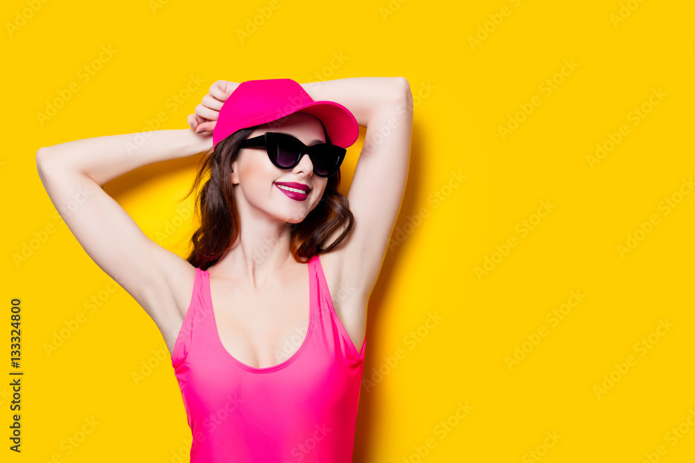 Elegant brunette woman in pink swimsuit and fashion cap. Sexy la Elegant brunette woman in pink swimsuit and fashion cap. Sexy la