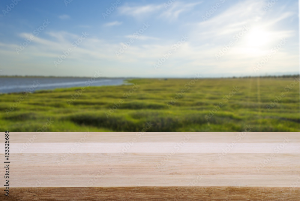 Empty wooden table and landscape background of forest lake and sky with sunshine. 