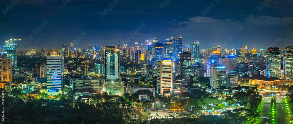 Beautiful skyline panorama of Jakarta city, Indonesia showing skyscraper buildings from top, aerial view at night.
