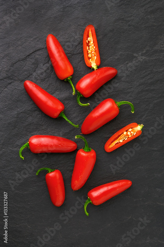 Flat lay red chili peppers on black background. Top view