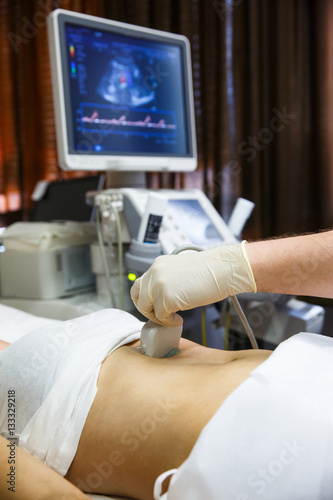 Obraz na płótnie Doctor doing an ultrasound on a patient abdomen w salonie