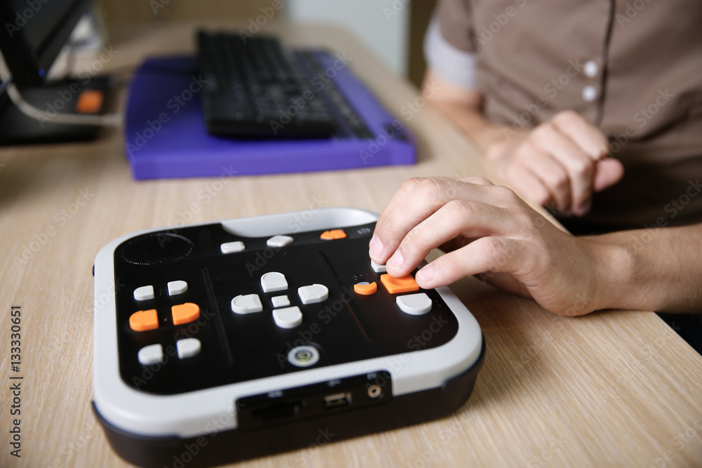 Blind person using audio book player for visually impaired