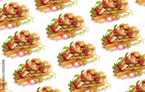 Pattern of vegetarian sandwich with fried wild yellow oiled boletuses and red whortleberry on white background photo