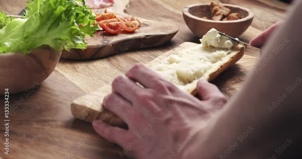 man spread cream cheese with herbs over baguette in slow motion, 4k 60fps prores footage man spread cream cheese with herbs over baguette in slow motion, 4k 60fps prores footage