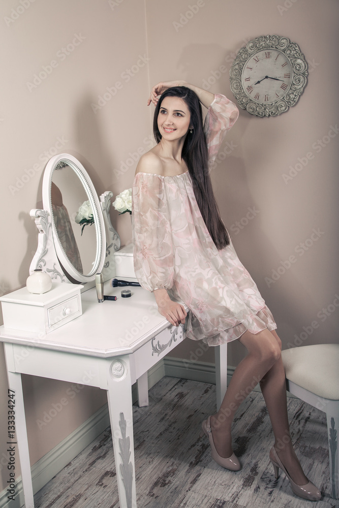 Φωτογραφία Beautiful happy woman with pink dress and long black hair in her room near her dressing table posing before party