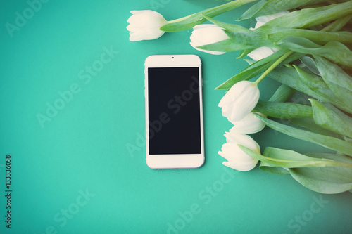 Fototapeta Naklejka Na Ścianę i Meble -  White mobile phone and bouquet of tulips