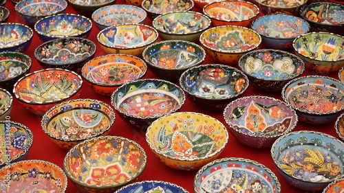 Colorful souvenirs hand painted ceramic utensils, plates and bowls on market