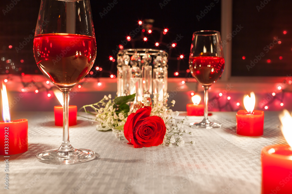 Romantic dinner with wine, candles and a red rose on a table Stock Photo |  Adobe Stock