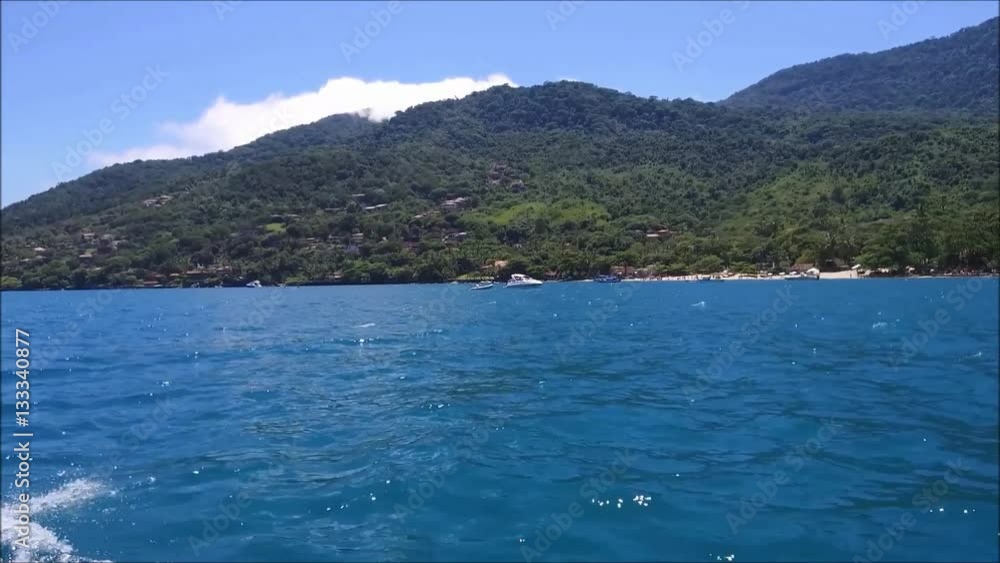 Boat sailing near the Ilha Bela island coast line in Brazil Boat sailing near the Ilha Bela island coast line in Brazil