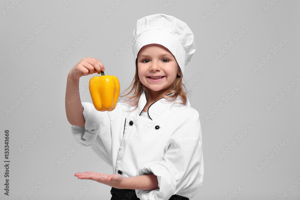 Cute girl in chef uniform on light background Cute girl in chef uniform on light background