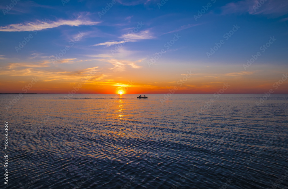 Sunset with silhouette of boat.