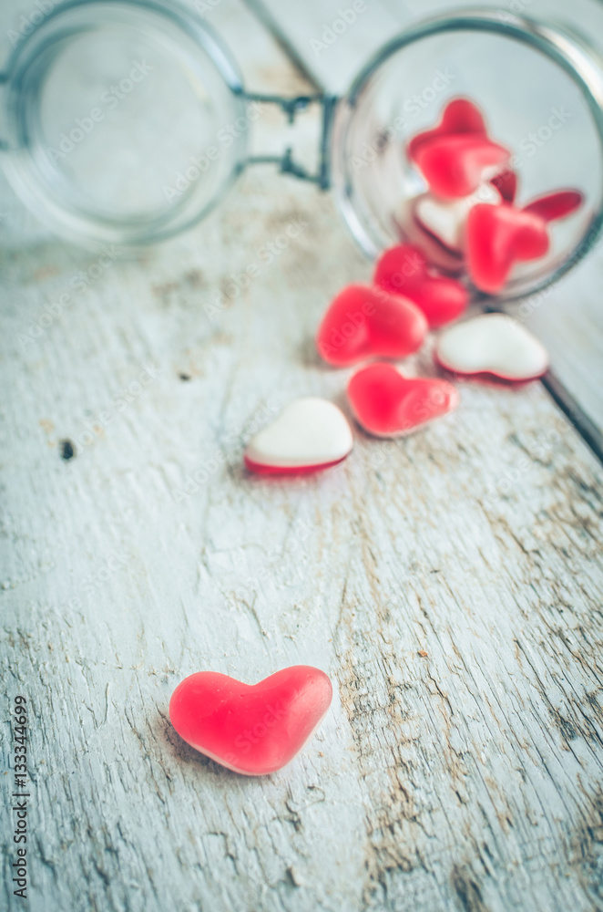 Fototapeta premium Red heart shape candy in a glass jar
