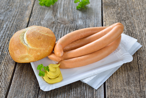фотографія Streetfood: Zwei Paar Wiener Würstchen mit scharfem Senf und Semmel auf einem Pa