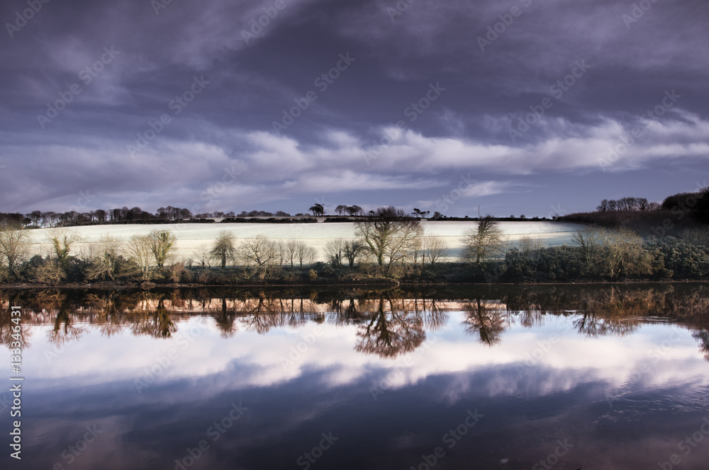Frozen Winter Landscape with Trees Reflecting in River