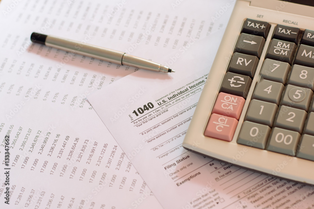 US tax form with pen and calculator selective focus / taxation c US tax form with pen and calculator selective focus / taxation c