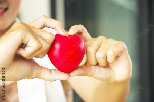 Woman is holding heart shape. Sign of love.