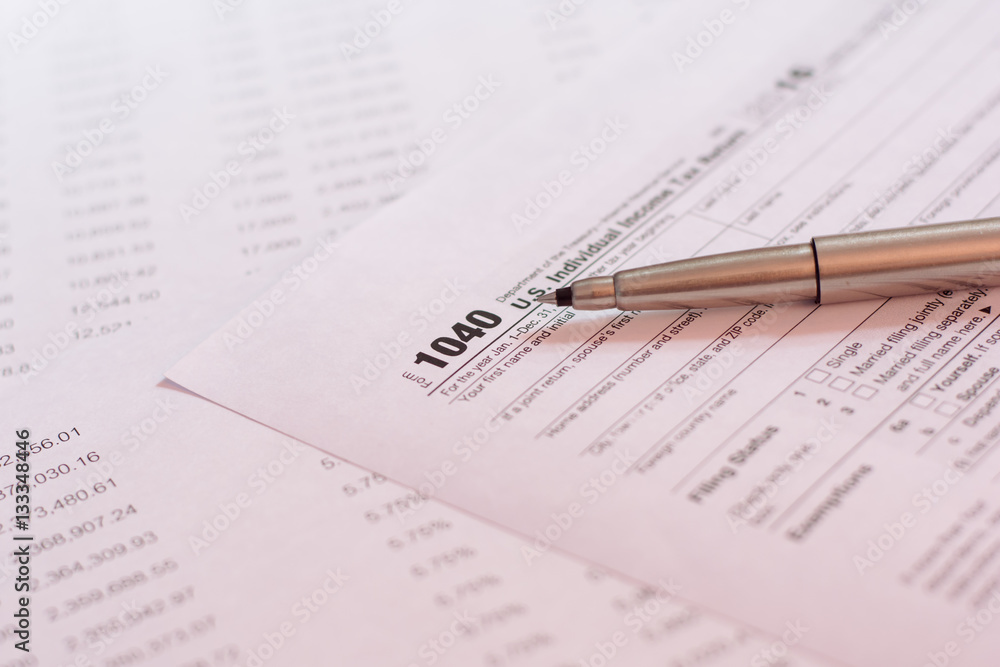US tax form with pen and calculator selective focus / taxation c US tax form with pen and calculator selective focus / taxation c