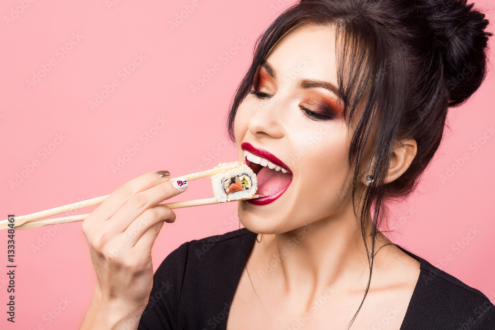 Beauty sexy woman eating sushi. Sushi rolls. Fashion model girl eating Sushi with chopsticks. Perfect make up and bob haircut, eating healthy japanese food. Diet, dieting concept. sexy girl, Close-up Beauty sexy woman eating sushi. Sushi rolls. Fashion model girl eating Sushi with chopsticks. Perfect make up and bob haircut, eating healthy japanese food. Diet, dieting concept. sexy girl, Close-up