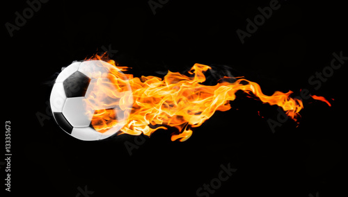 Flying football or soccer ball on fire. Isolated on black background.