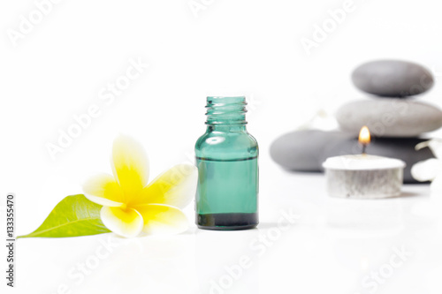 Green cosmetic bottles with zen stones and frangipani flower