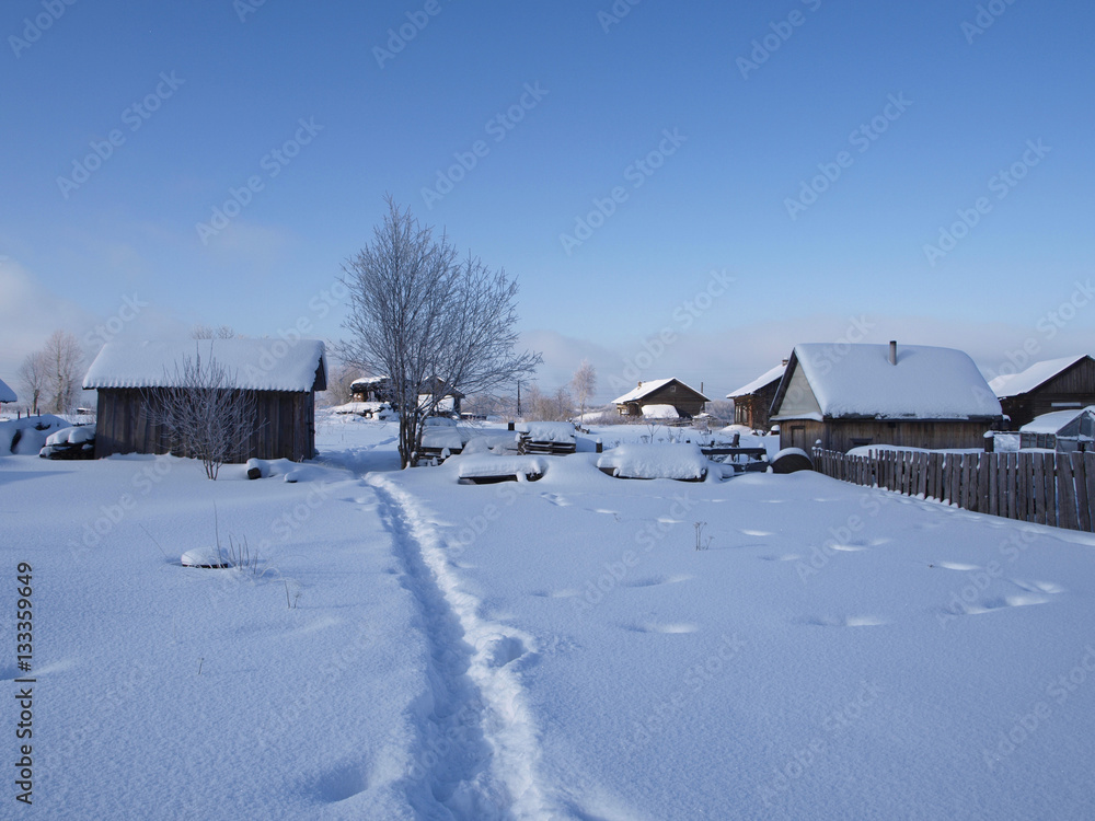 Rural winter landscape houses with footpath in snow Rural winter landscape houses with footpath in snow