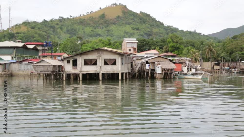 in coron philippines the antique stilts house for poor people dirty and boat near water. in coron philippines the antique stilts house for poor people dirty and boat near water.