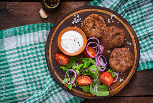 Appetizing meat cutlet and tomato salad with arugula