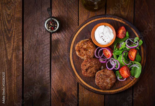 Photos Appetizing meat cutlet and tomato salad with arugula