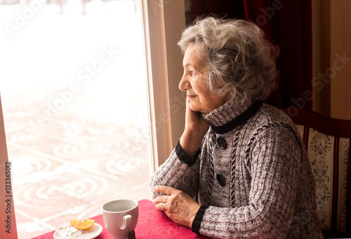 Canvastavla Lonely senior woman sitting and drinking tea in restaurant
