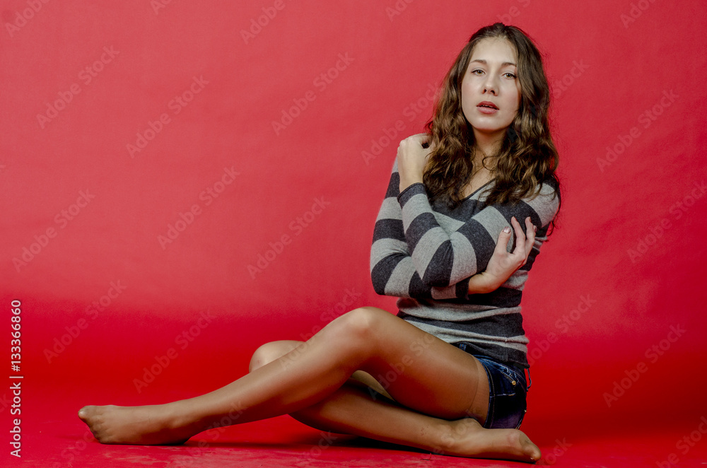 Young cheerful girl in denim shorts and a striped sweater walking in the youthful style
Young cheerful girl in denim shorts and a striped sweater walking in the youthful style